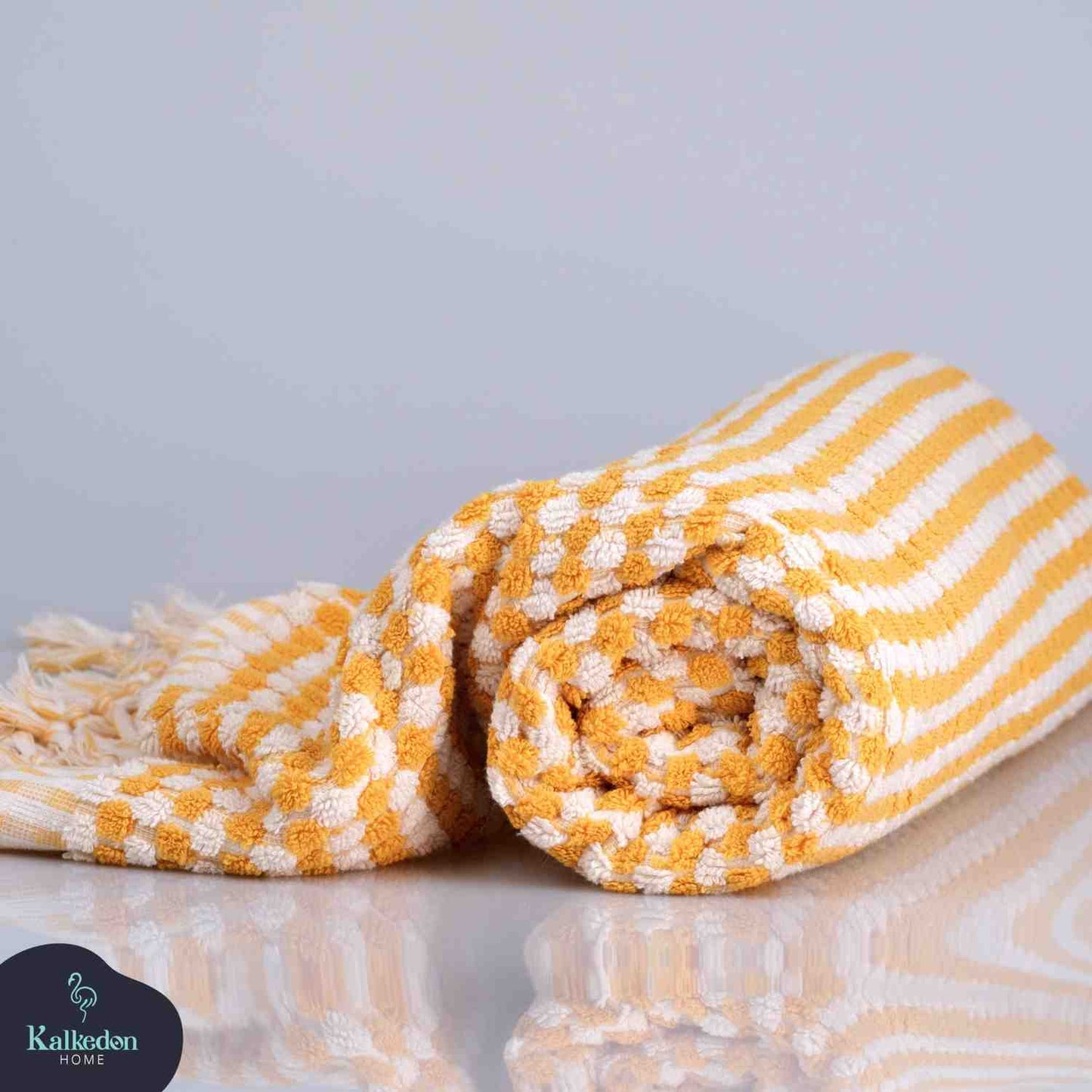 mustard pom pom bath towel folded