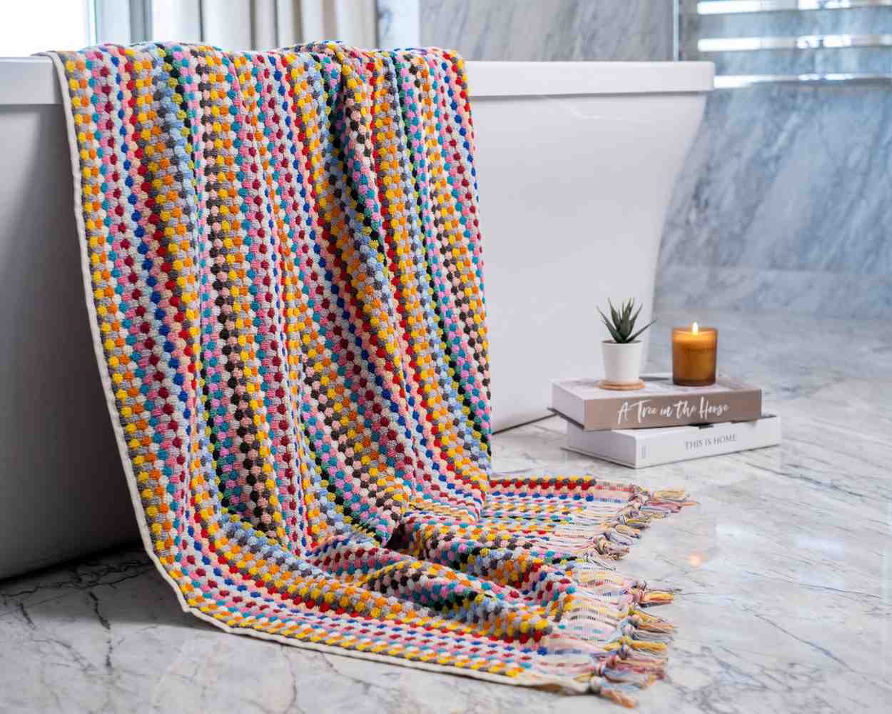 Eco-friendly pom pom bath towel made with long fiber organic cotton, extra large and plush with a trendy jacquard weave.