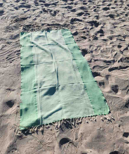 green yansima turkish towel on the beach